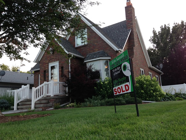 For sale sign in front of a single-family home