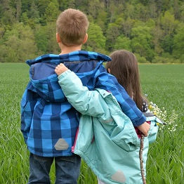 Two children walking arm and arm