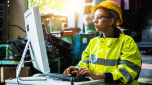 young woman working at computer wearing protective gear